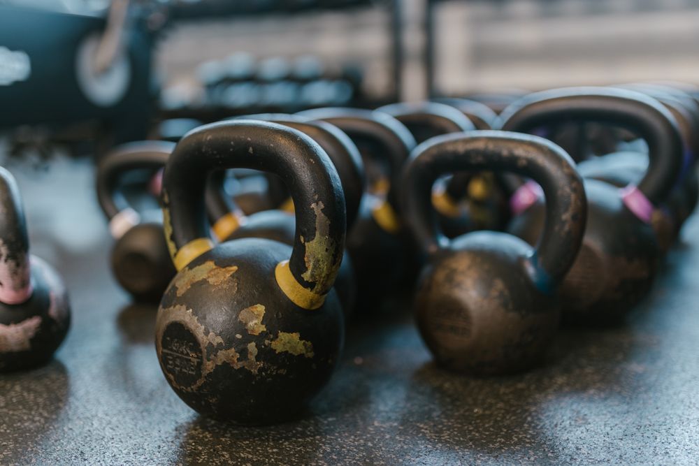 Sorte kettlebells på en gummigulv i et træningslokale