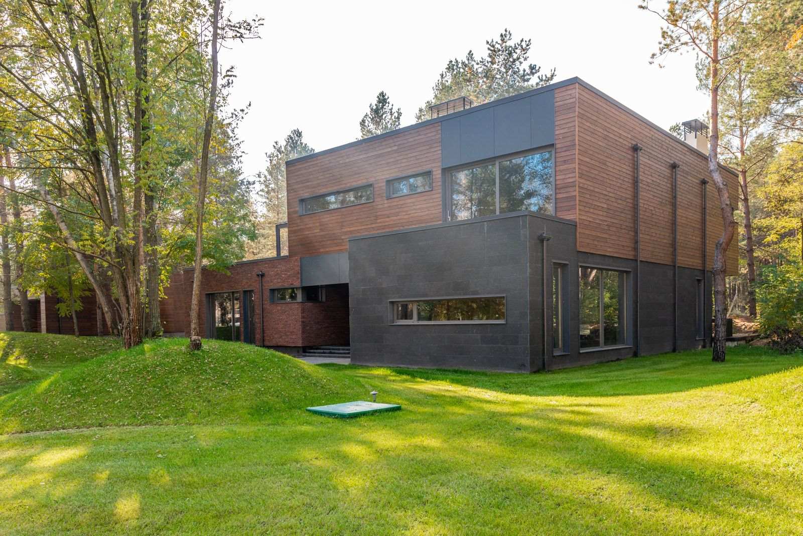 Moderne hus med træbeklædt facade set fra en græsplæne